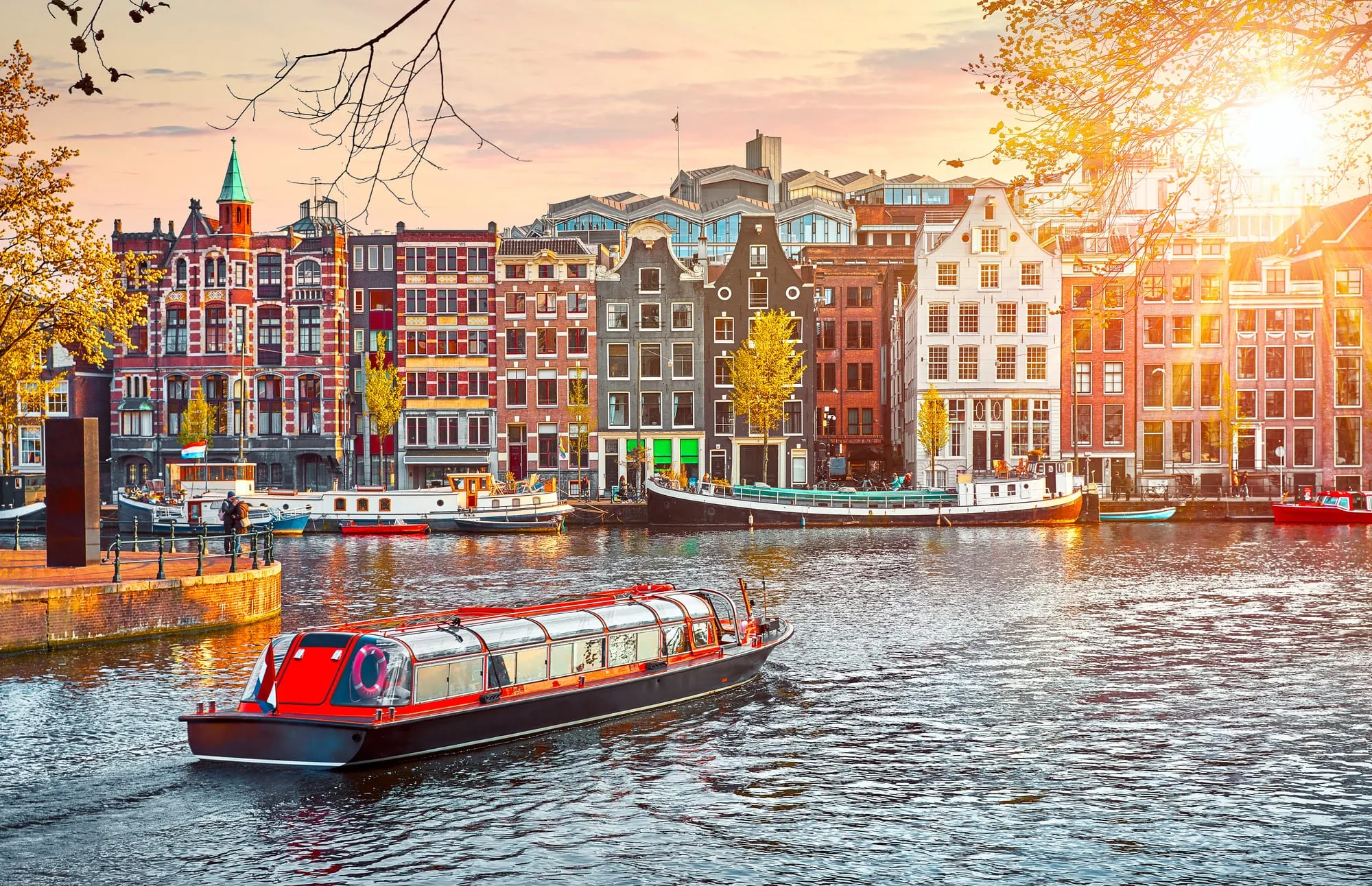 Colourful canal houses in Amsterdam with a tour boat on the water