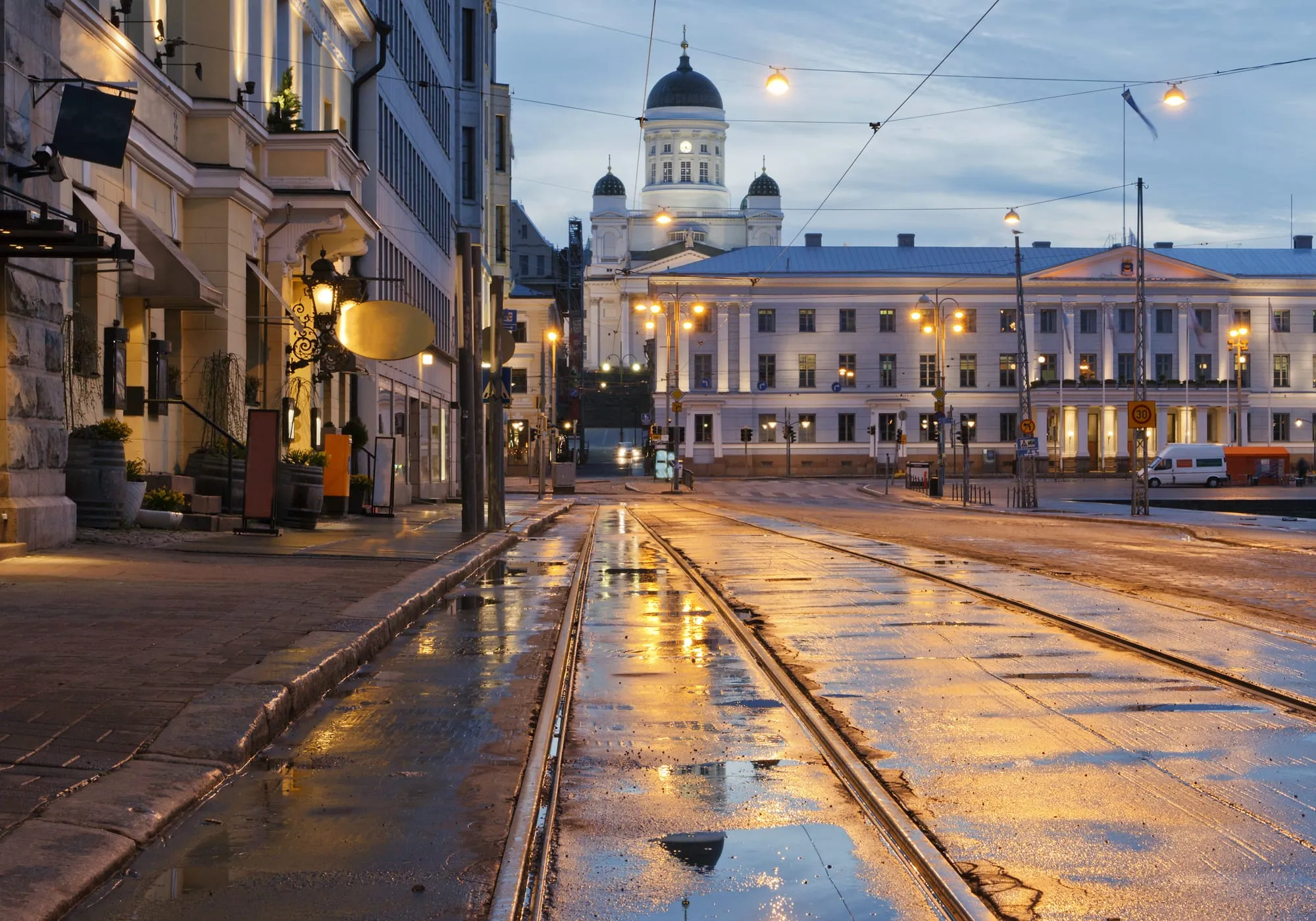 Helsinki Cathedral above Senate Square at dusk, with tram tracks shining after rain