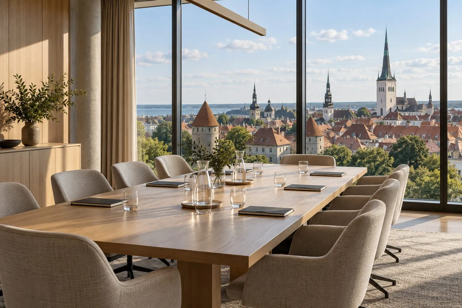Modern meeting room with a long wooden table and floor-to-ceiling windows overlooking a medieval old town with red roofs and church spires