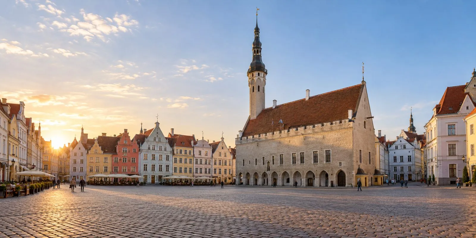 Tallinn Town Hall Square at golden hour, lined with colourful merchant houses